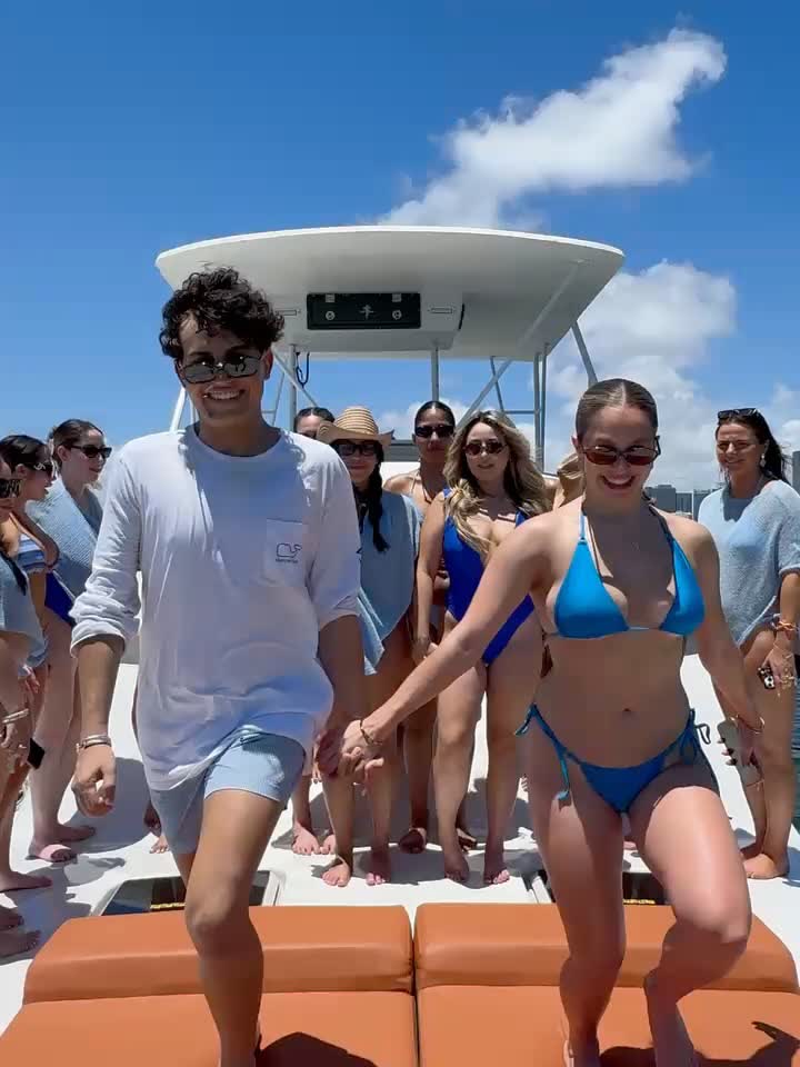 Guests standing along the bow of the Chris Craft on the orange sunpads, mid-charter