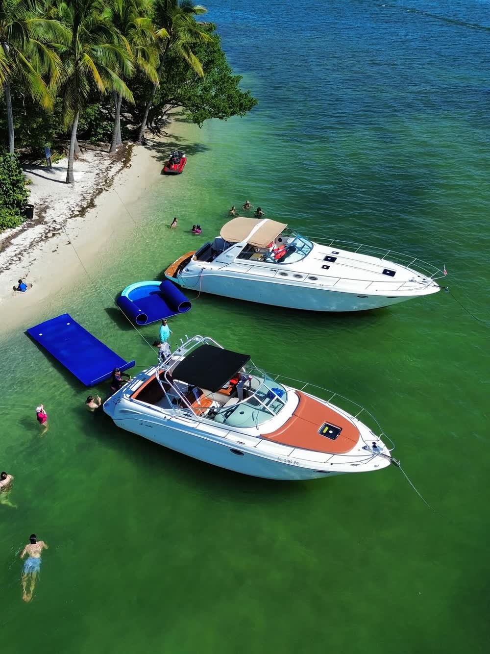 Aerial of two LuxSea boats rafted together at the sandbar with the float mat out