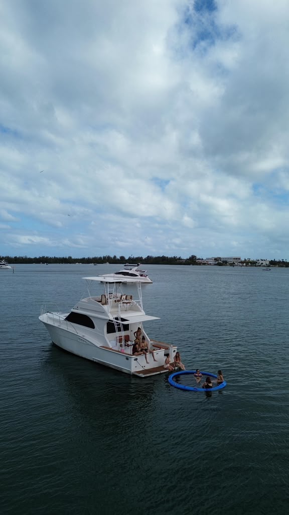 The Chris Craft at anchor off the shoreline with the swim float streamed astern