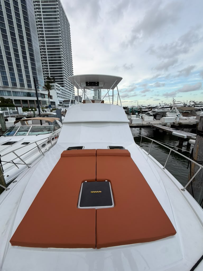 The bow sunpads laid out, marina and towers behind