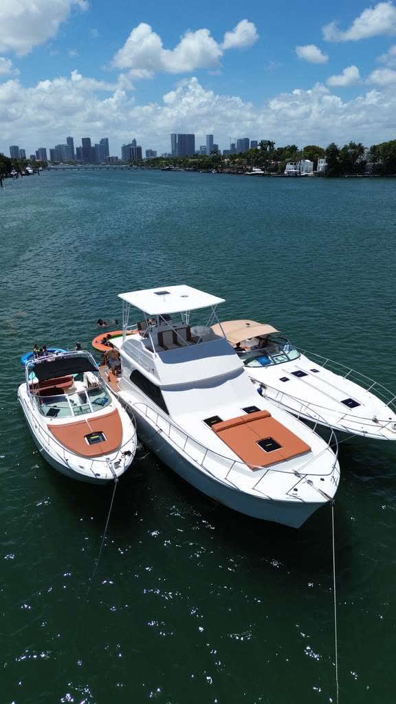 Two LuxSea boats tied alongside each other with the downtown Miami skyline across the water