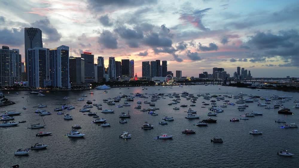Aerial of the anchorage at dusk, pink cloud over dozens of boats